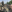 A group of soldiers smile for a selfie while seated in a pickup truck in Ukraine. The faces of all but one - Canadian Dave Smith - are blurred.